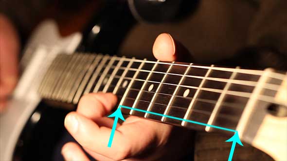 Guitar string vibrating behind hand